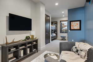 Living area with recessed lighting, baseboards, and light colored carpet