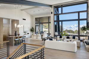 Living room featuring plenty of natural light, light wood-style flooring, visible vents, and high vaulted ceiling