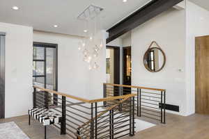 Interior space featuring baseboards, visible vents, wood finished floors, an upstairs landing, and recessed lighting