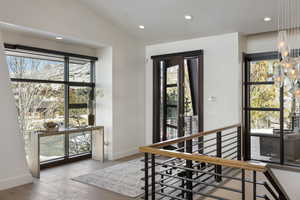 Foyer with lofted ceiling, recessed lighting, hardwood / wood-style flooring, and baseboards