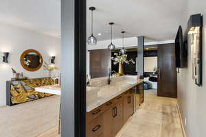 Kitchen featuring decorative light fixtures, light countertops, a sink, modern cabinets, and baseboards