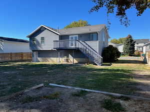 Rear view of house with stairs, a yard, fence, and a wooden deck