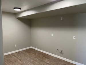 Finished basement featuring baseboards and dark wood-style flooring