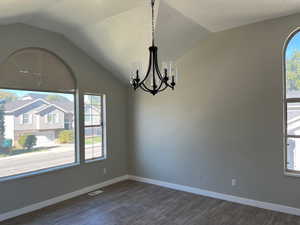 Bedroom with vaulted ceiling, dark wood finished floors, and a wealth of natural light