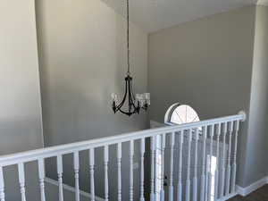 Details with a textured ceiling and a notable chandelier