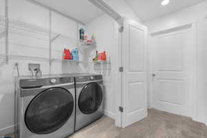 Clothes washing area with washer and dryer, laundry area, baseboards, and recessed lighting