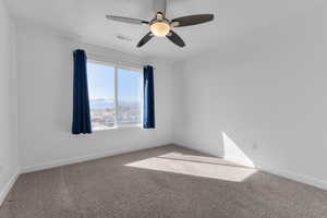 Spare room featuring a ceiling fan, carpet, visible vents, and baseboards