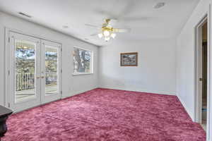 Carpeted spare room with a textured ceiling, french doors, visible vents, and baseboards