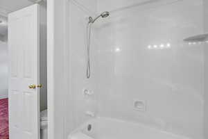 Bathroom featuring bathing tub / shower combination and toilet