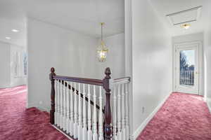 Hallway featuring carpet floors, recessed lighting, baseboards, and an upstairs landing