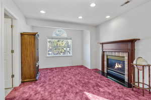 Living room with recessed lighting, carpet floors, visible vents, baseboards, and a brick fireplace