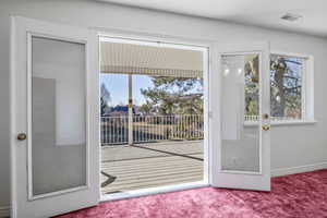 Doorway with carpet flooring and visible vents