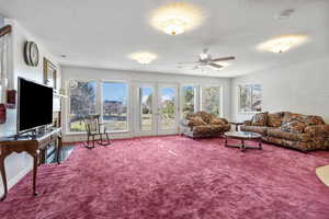 Living room featuring carpet floors, french doors, and a textured ceiling