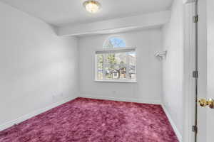 Carpeted spare room featuring baseboards