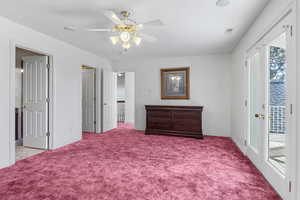 Carpeted bedroom featuring access to outside, a ceiling fan, and baseboards