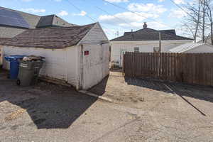 Exterior space with an outbuilding, a storage unit, and fence