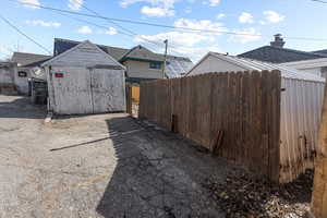 View of yard with an outbuilding, a storage unit, and fence