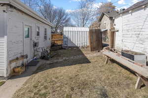 View of yard featuring a shed, fence, and an outdoor structure