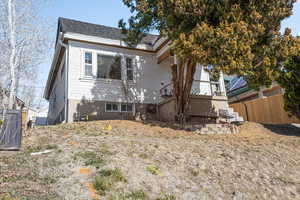 Back of house featuring roof with shingles, fence, and central air condition unit