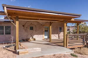 Exterior space featuring a patio area, a deck, and stucco siding