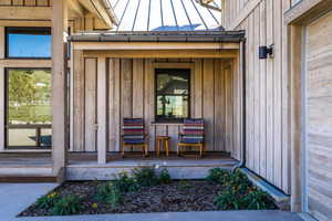 Property entrance with board and batten siding, a standing seam roof, and metal roof