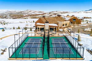 View of tennis court with fence and a mountain view