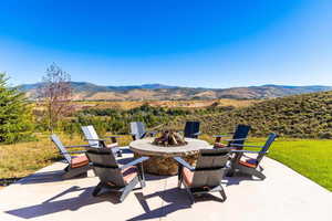 View of patio / terrace featuring an outdoor fire pit and a mountain view