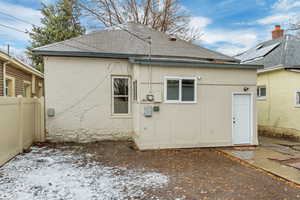 Back of house with brick siding, fence, a patio, and roof with shingles