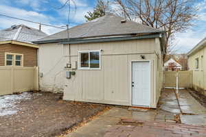 Rear view of house with brick siding, a shingled roof, fence, and a gate