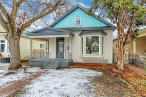 View of front facade featuring central AC unit, fence, and stucco siding