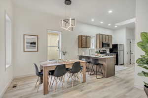 Dining room featuring recessed lighting, a skylight, visible vents, baseboards, and light wood-style floors