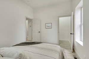 Bedroom featuring light wood finished floors, baseboards, and visible vents