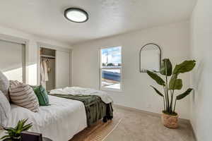 Bedroom featuring light carpet and baseboards