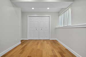 Unfurnished bedroom featuring light wood-style floors, a closet, recessed lighting, and baseboards