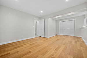 Unfurnished bedroom featuring baseboards, a closet, recessed lighting, and light wood-style floors