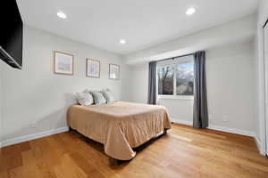 Bedroom with light wood-style floors, recessed lighting, and baseboards