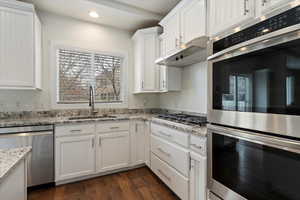 Kitchen featuring recessed lighting, appliances with stainless steel finishes, white cabinetry, a sink, and under cabinet range hood