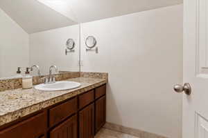 Bathroom featuring tile patterned flooring, vanity, and baseboards