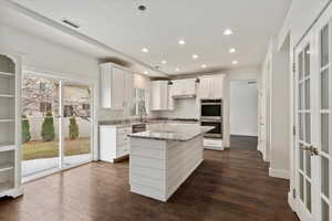 Kitchen with recessed lighting, stainless steel appliances, a sink, white cabinets, and dark wood-style floors