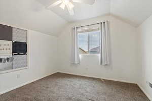 Additional living space featuring carpet floors, lofted ceiling, baseboards, and a ceiling fan