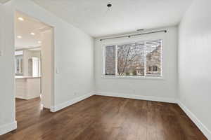 Spare room featuring dark wood-style floors, baseboards, and recessed lighting