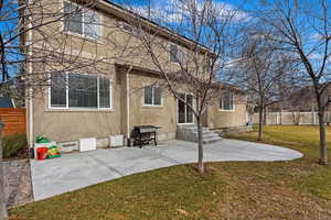 Rear view of house featuring a yard, a patio, stucco siding, crawl space, and fence