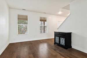 Spare room featuring visible vents, baseboards, and wood finished floors