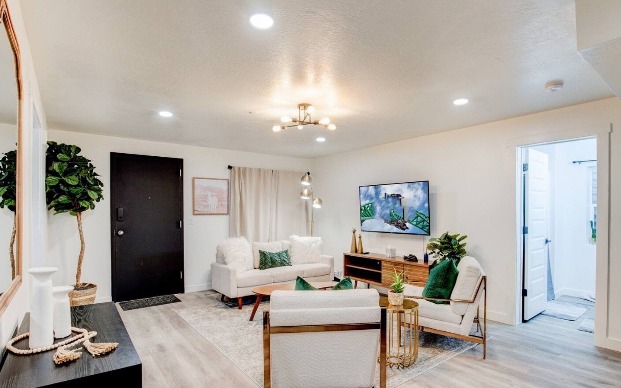 Living area with light wood-style flooring, baseboards, a notable chandelier, and recessed lighting