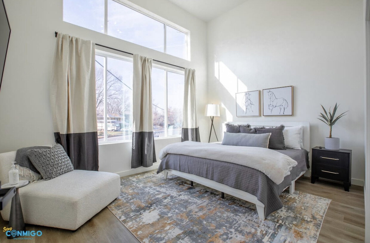 Bedroom featuring a high ceiling, wood finished floors, and baseboards