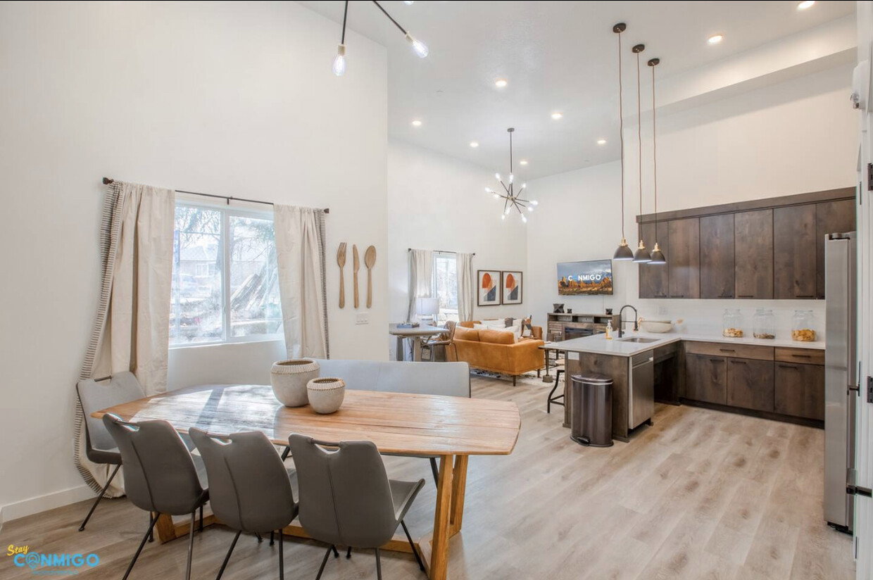 Dining area with light wood finished floors, recessed lighting, a high ceiling, and an inviting chandelier