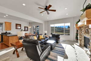 Living area featuring ceiling fan, recessed lighting, and a stone fireplace