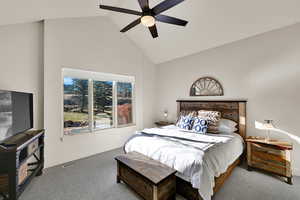 Bedroom featuring carpet floors, ceiling fan, and high vaulted ceiling
