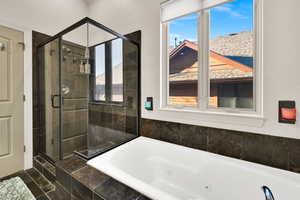 Full bathroom with a tub with jets and a stall shower