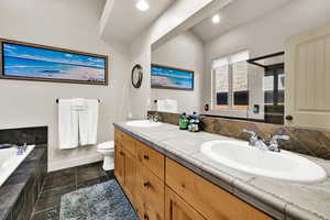 Full bathroom with double vanity, a garden tub, and a shower